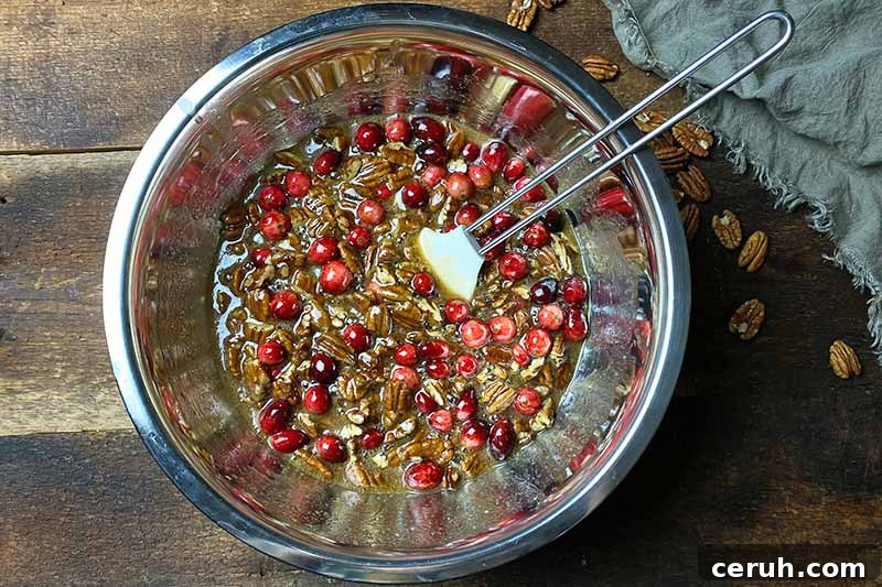 Horizontal image of mixing together a fruit and nut filling with a spatula.