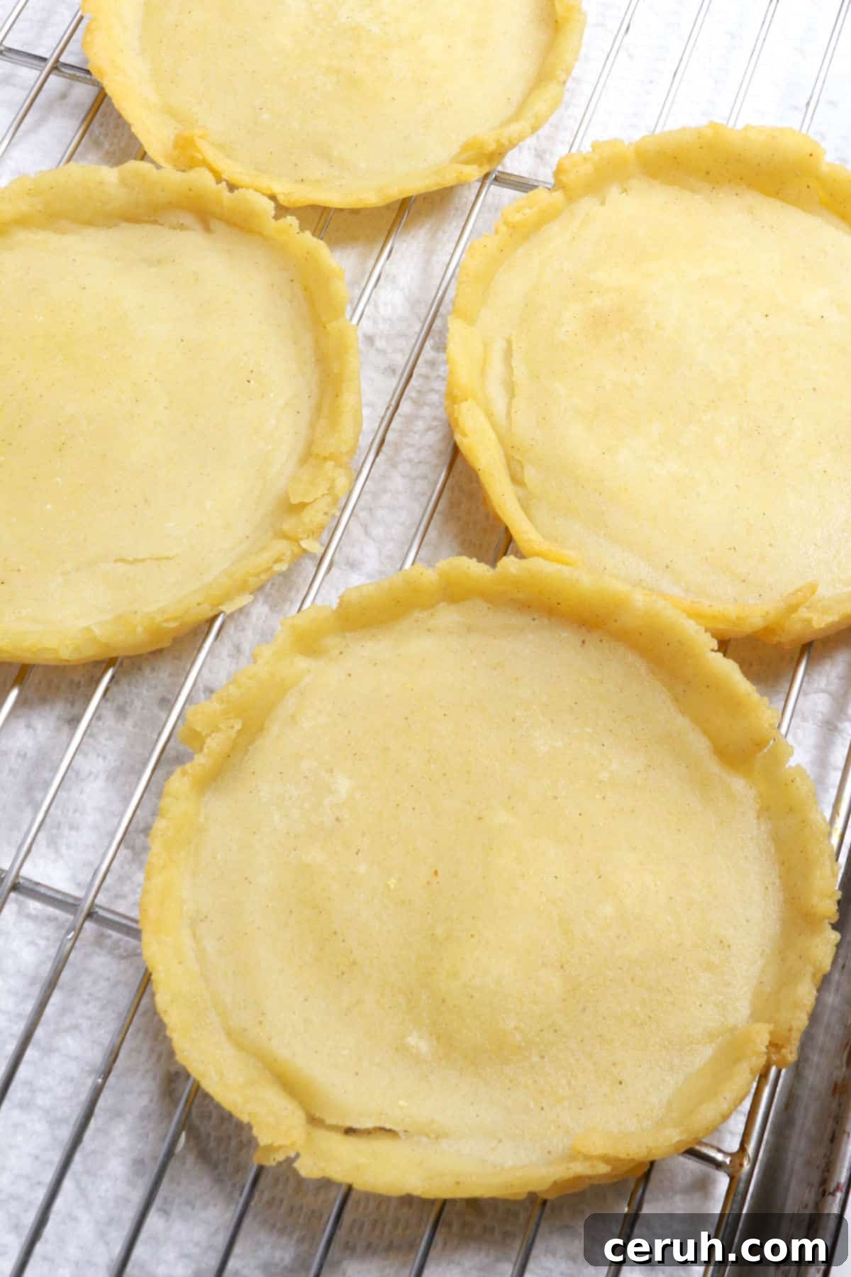 Fried sopes on a wire rack with paper towels underneath.