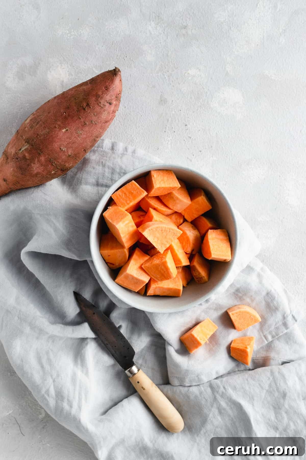 small bowl with chunks of sweet potato and a hand knife on side