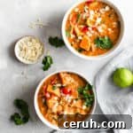 overhead shot of two small bowls with sweet potato curry with some toasted almonds and lime on side