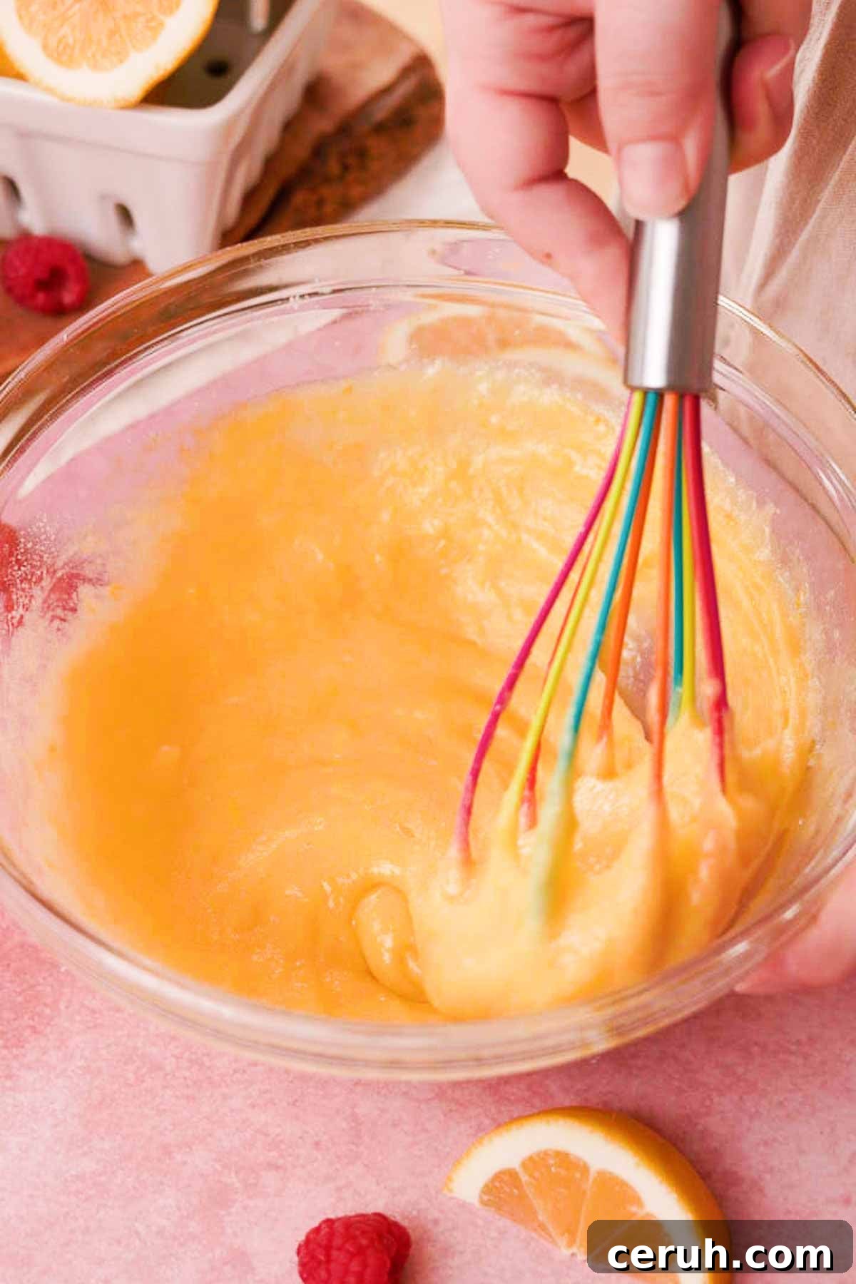 whisking eggs into the filling in a large glass bowl with a silicone whisk
