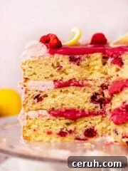 cross section of lemon raspberry layer cake with gooey raspberry curd filling