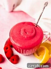 raspberry curd in glass teacup with silver spoon