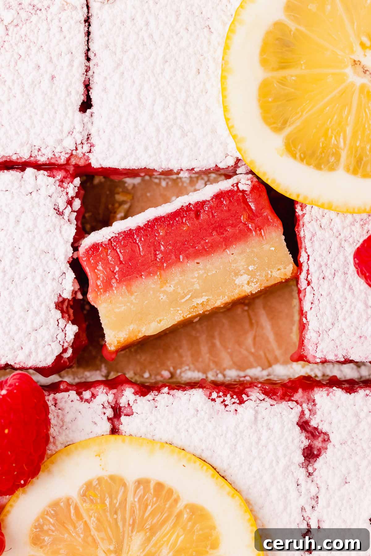 lemon raspberry bars from the top with one bar turned to show cross section
