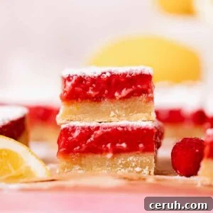 stacked lemon raspberry bars with shortbread crust and gooey, thick, red lemon raspberry filling