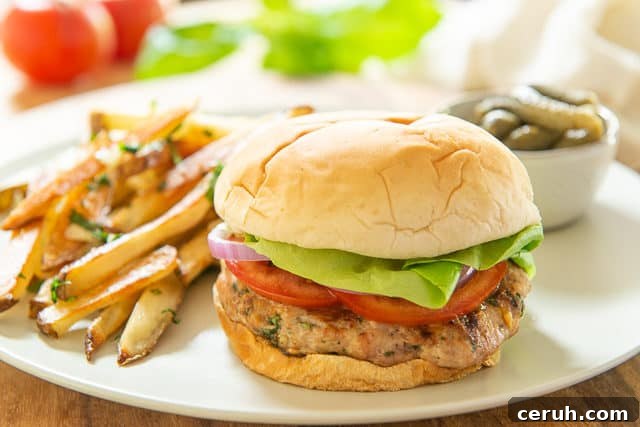 Juicy Turkey Burger Recipe with Flavorful Toppings 3 Turkey Burger Recipe - Served on Beige Plate with Pickles and Fries