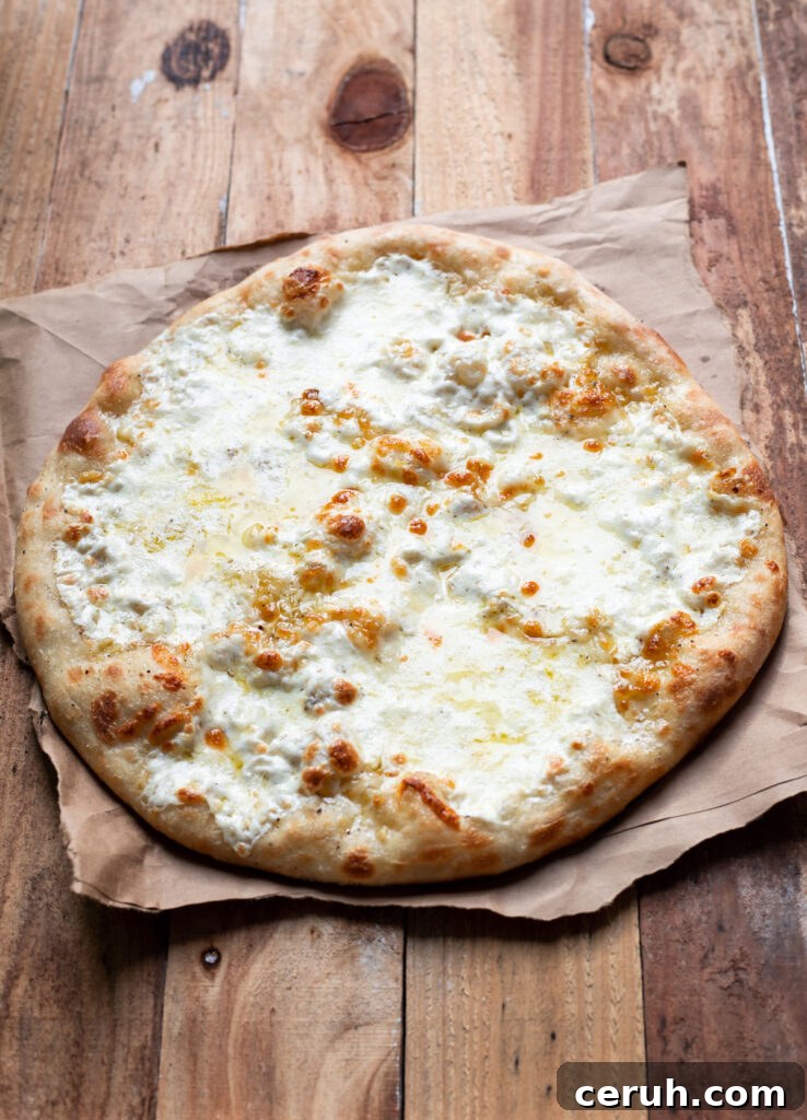 cheese pizza with caesar salad and tomatoes on top