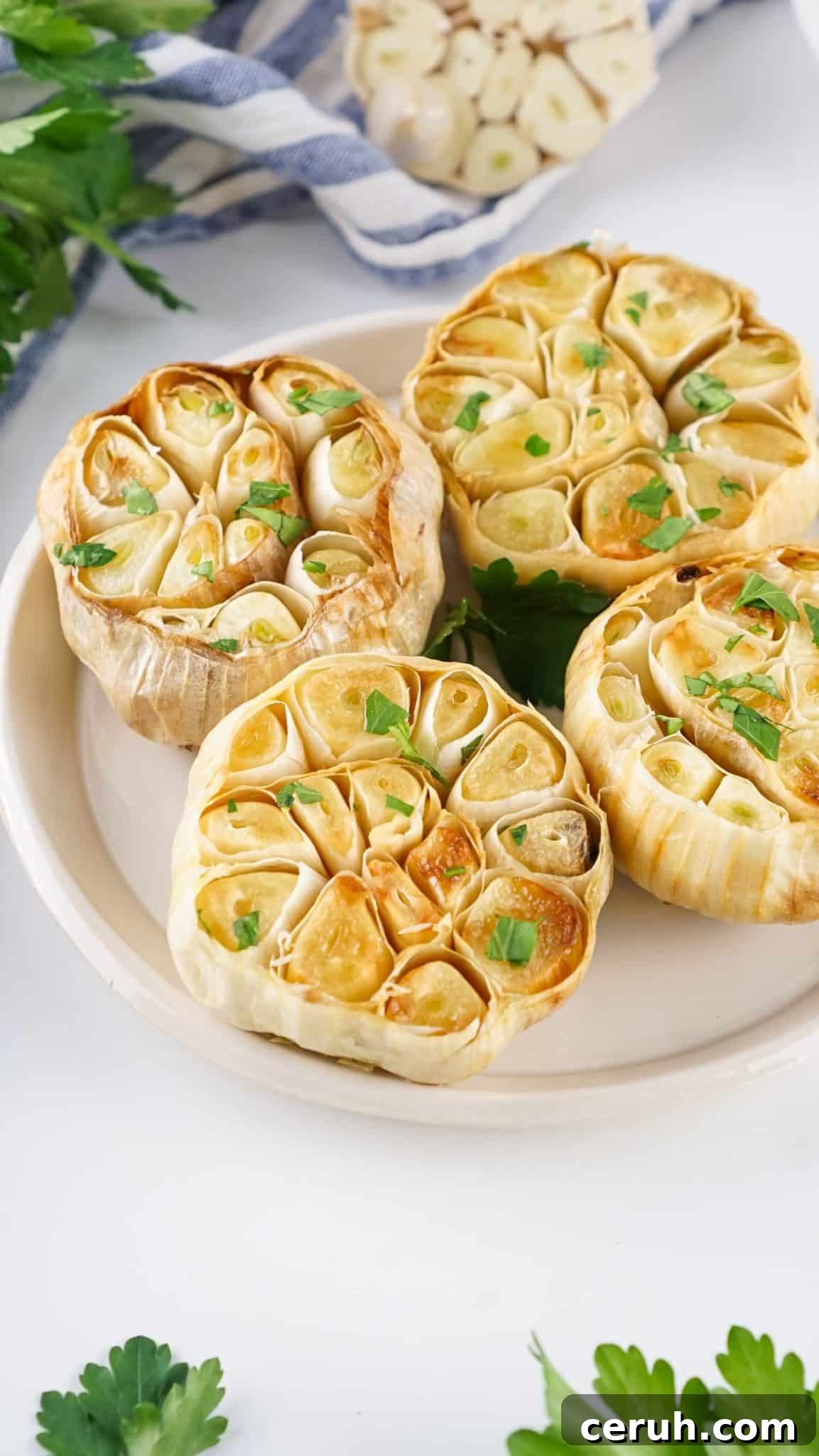 roasted garlic bulbs resting on a white plate