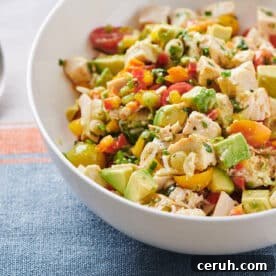 Chicken and Avocado Salad in white bowl next to spoon.