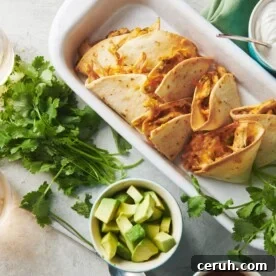 Baked chicken quesadillas in dish on table with toppings and drinks.