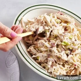 Scooping Chicken Salad out of bowl with fork.