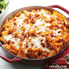 Chicken Parmesan Baked Ziti in red pan on table.