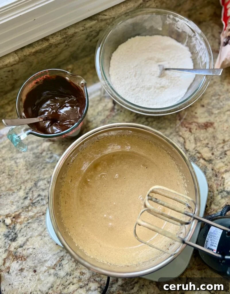 Three bowls contain chocolate, dry ingredients, and wet ingredients, respectively.