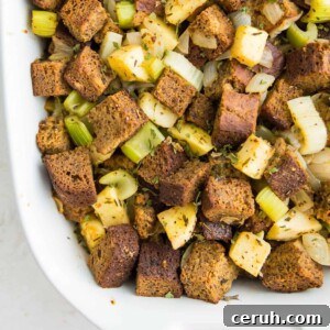 A casserole dish filled with paleo stuffing with chopped apples and celery in it.