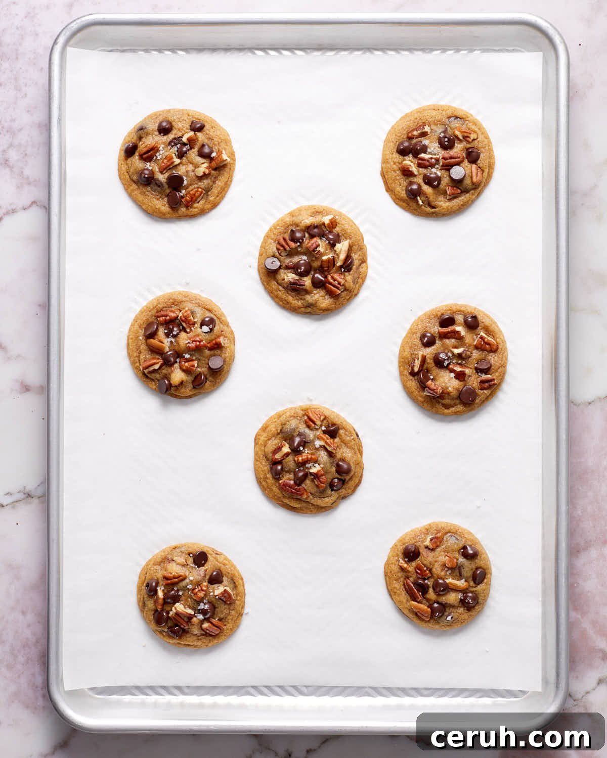 Chocolate Chip and Pecan Cookies — Chewy Oven-Baked Recipe 6 Baked cookies on a baking sheet.