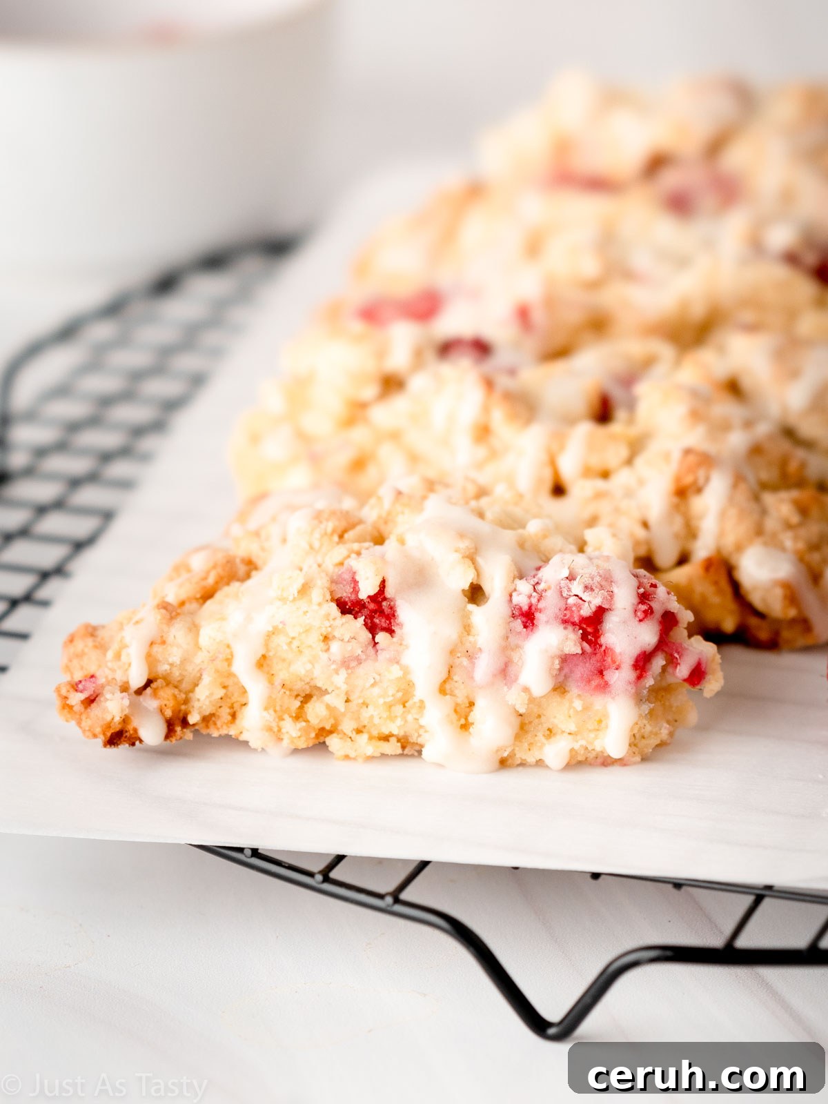 Close-up of a glazed white chocolate raspberry scone.
