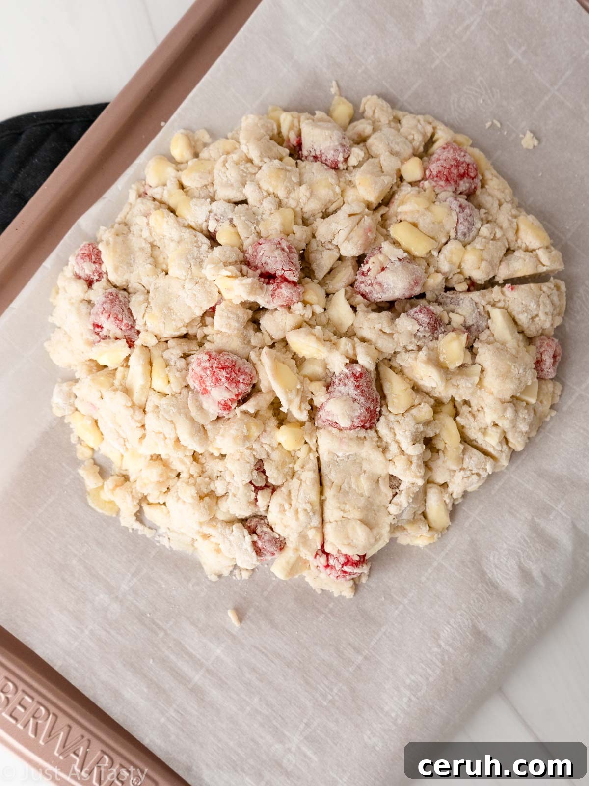 White chocolate raspberry scone dough shaped into a disc on baking sheet.