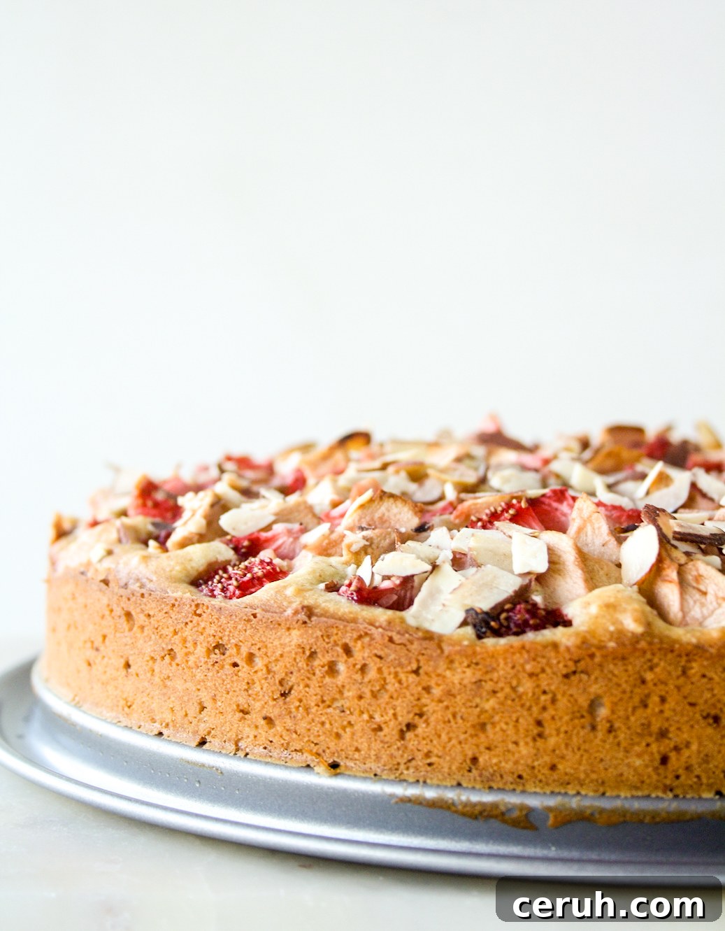 Tender almond and browned butter cake topped with fresh apples and strawberries