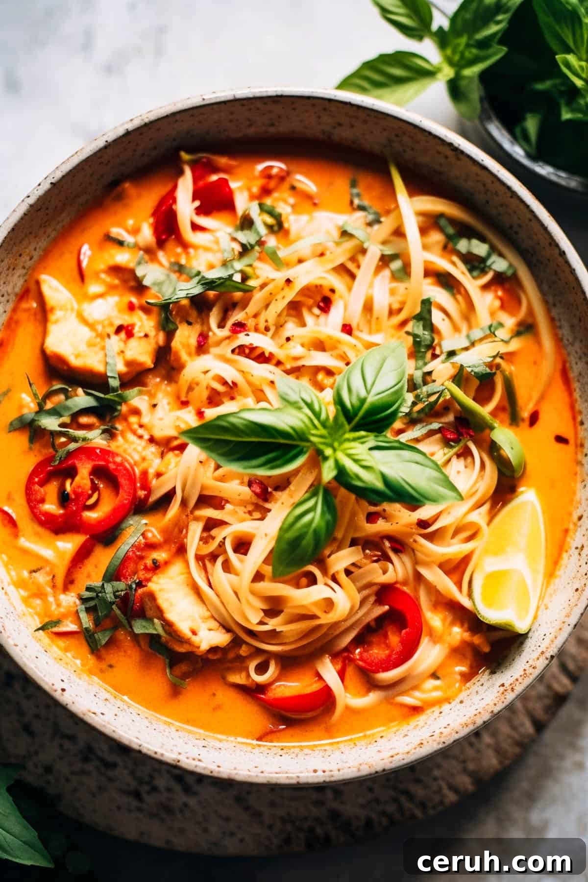 Thai red curry noodle soup with basil and peppers.