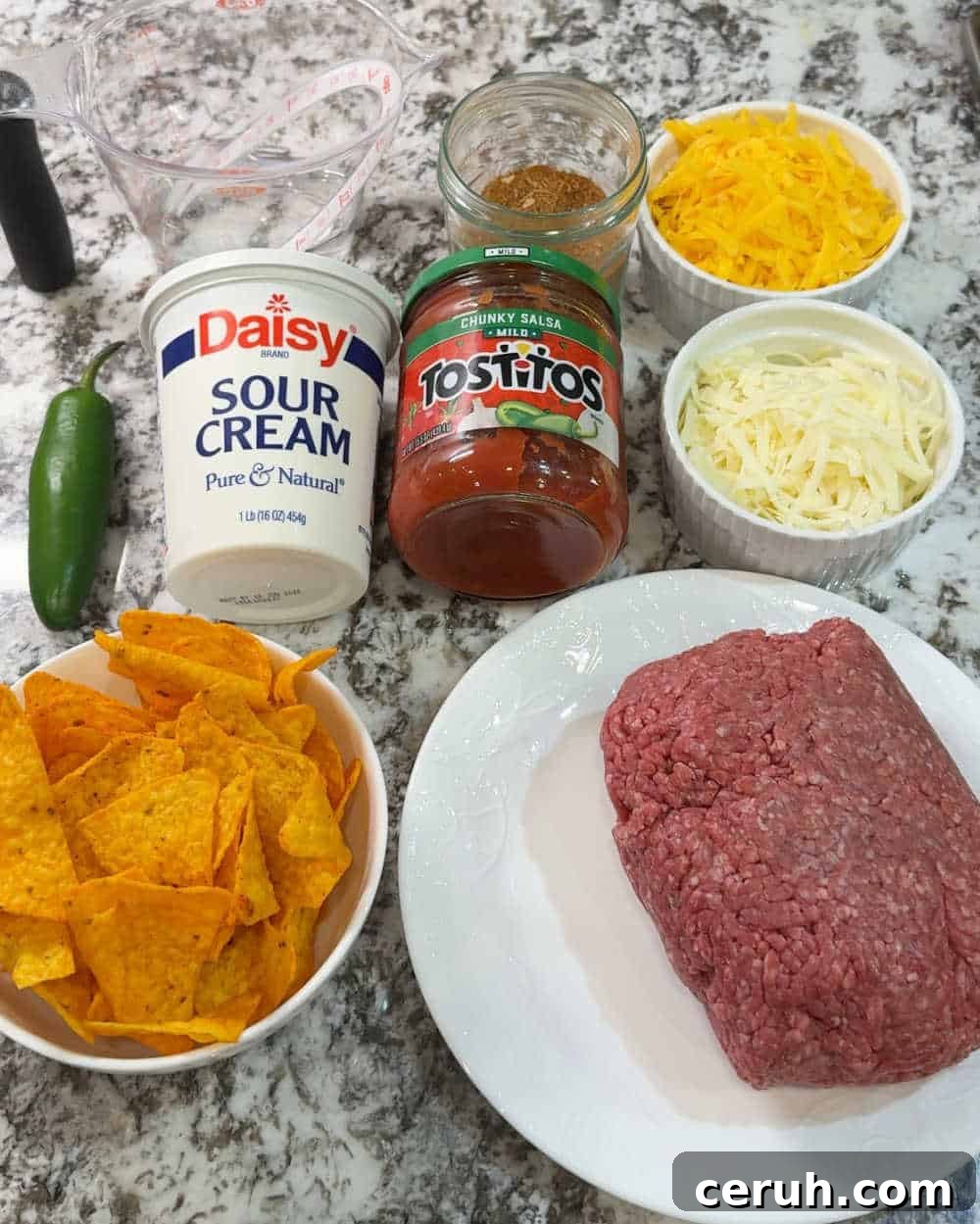 ground beef, Doritos, cheese, salsa, seasoning, sour cream and jalapeno.