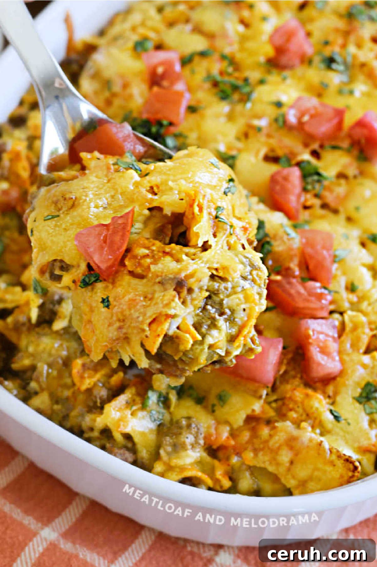 Dorito Casserole with ground beef and tomatoes on a serving spoon