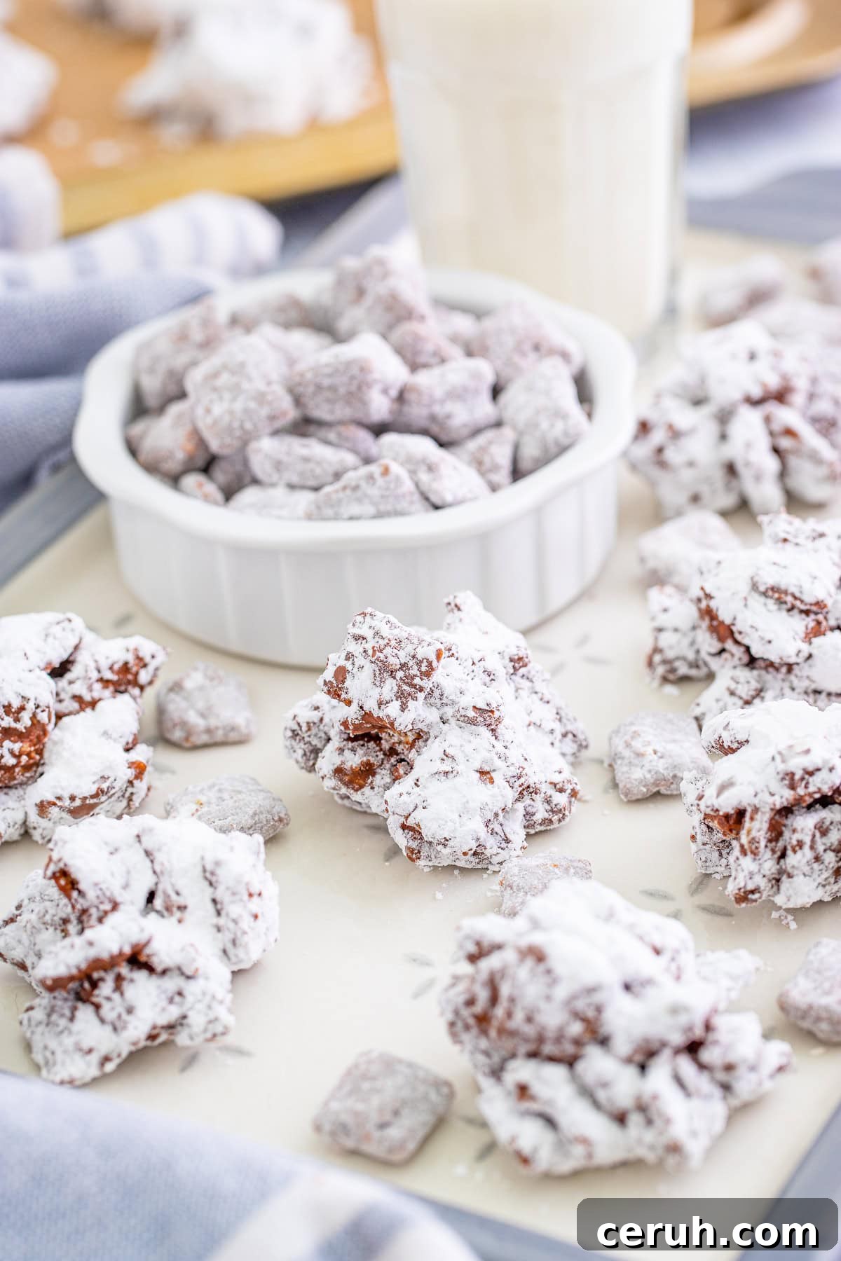 Tray full of Muddy Buddy Cookies with a bowl of Muddy Buddies.
