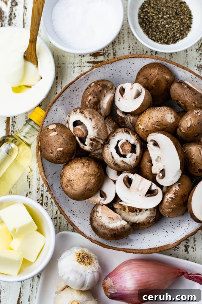 A bowl of raw mushrooms with butter shallots, sliced garlic and salt and pepper sit around the bowl.