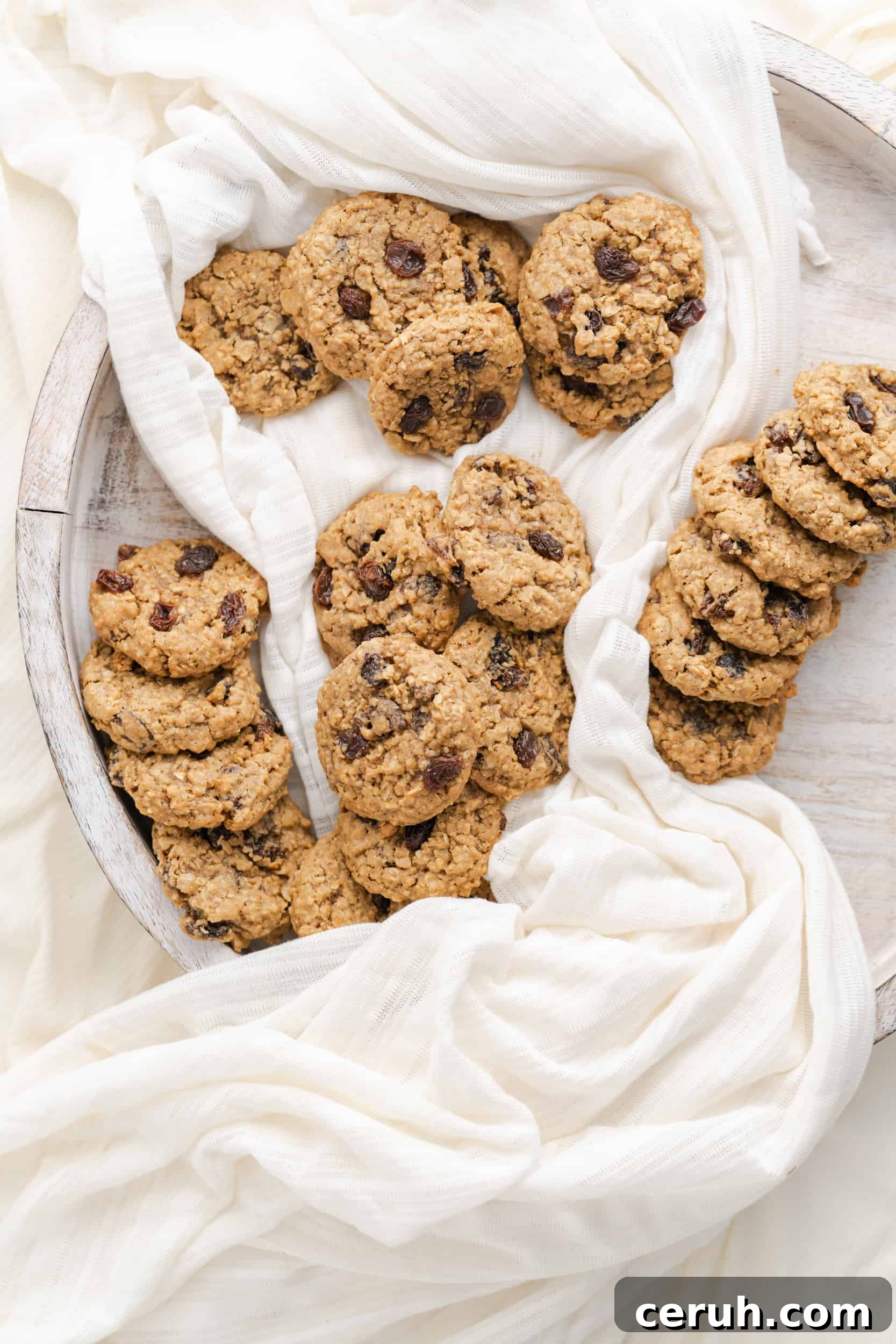Soft Chewy Oatmeal Raisin Cookies That Stay Moist Longer 4 Oatmeal cookies with raisins on a wooden platter.