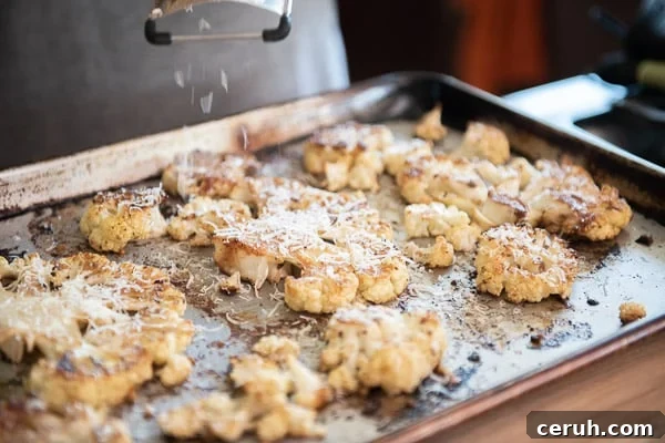 Grating cheese over roasted cauliflower