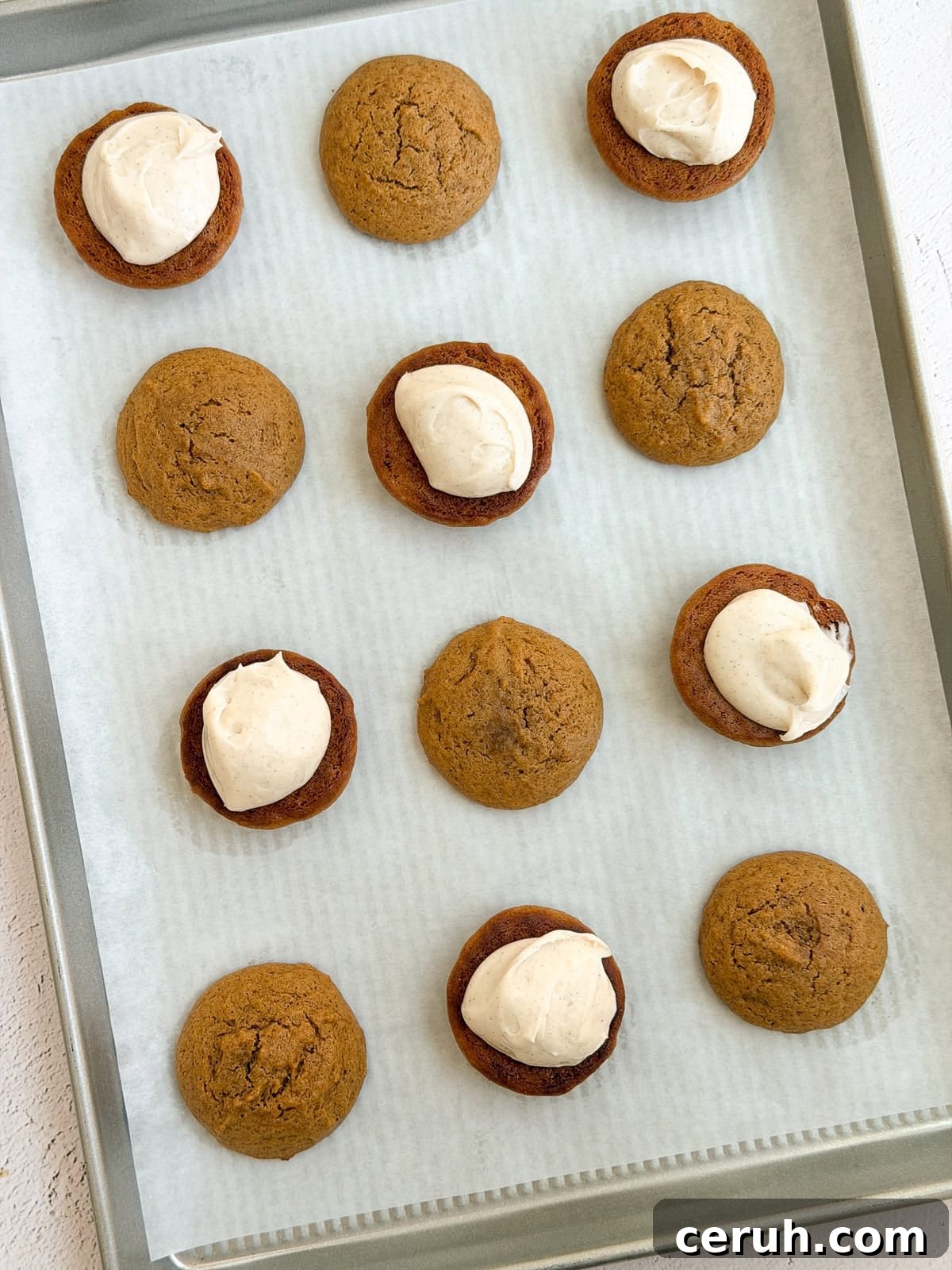 gingerbread whoopie pies being topped with the frosting.