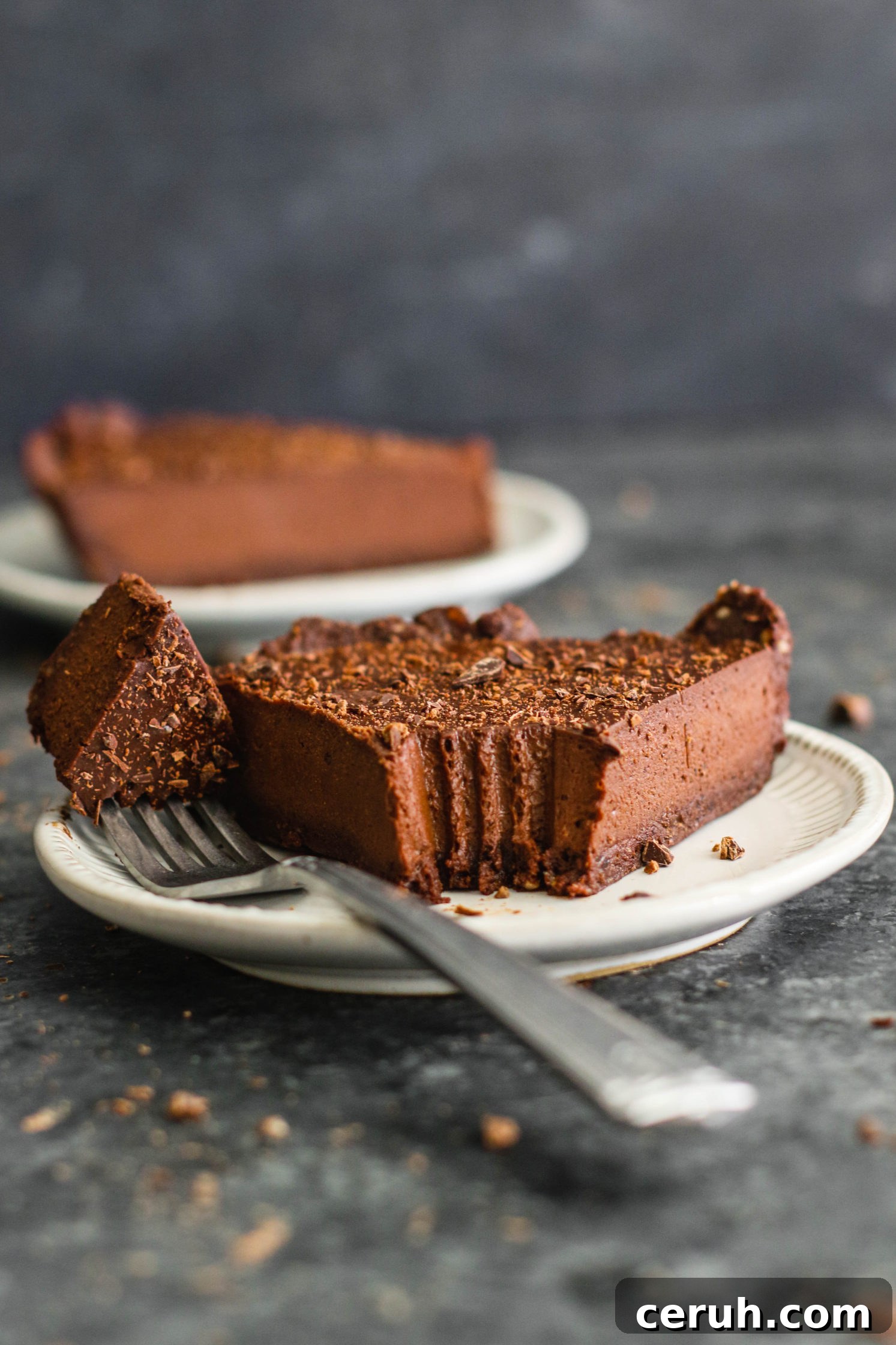 2 slices of Vegan Chocolate Pie plated with a bite missing from one by Flora & Vino