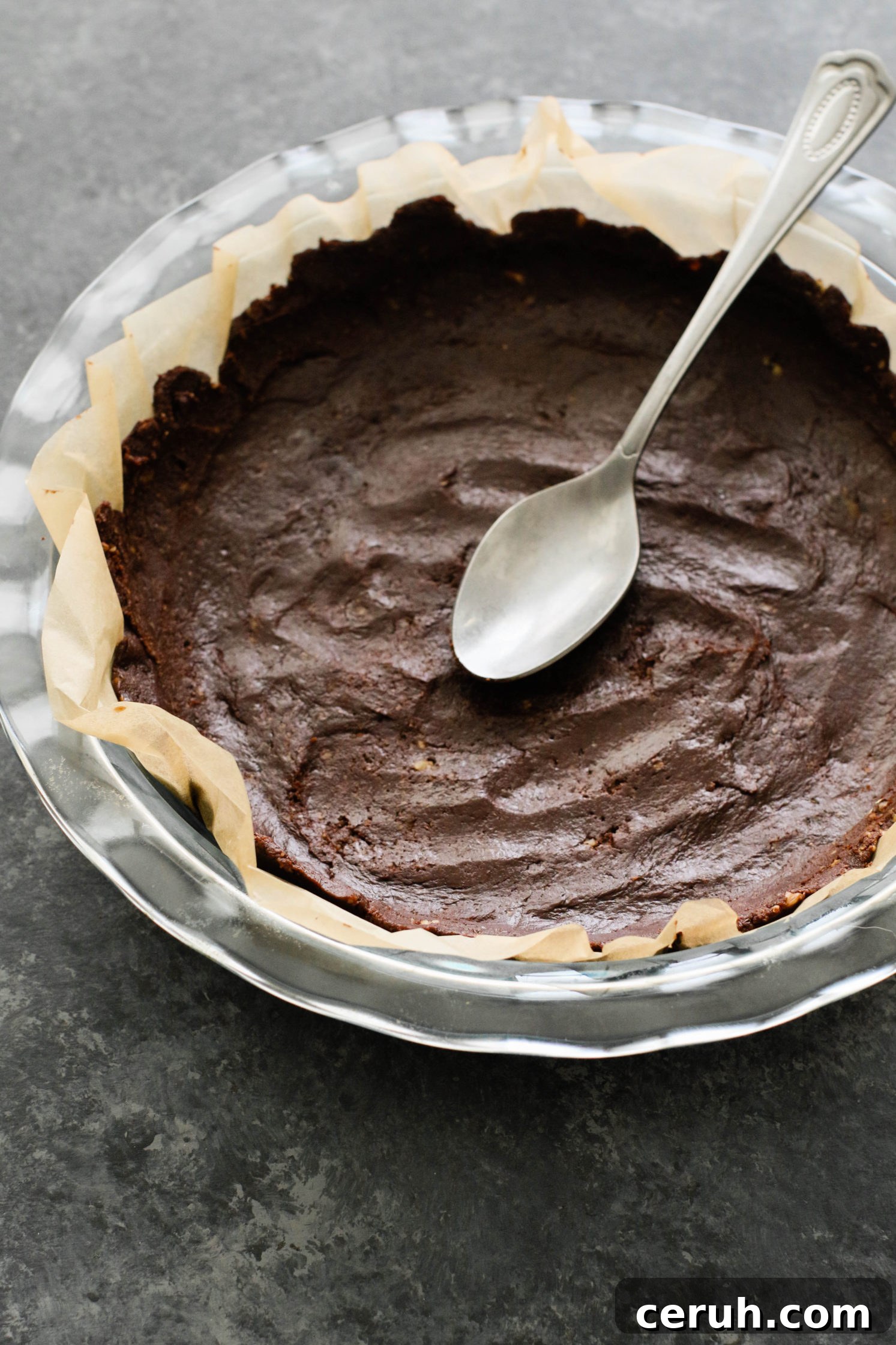 chocolate pie crust in pie pan lined with parchment paper by Flora & Vino
