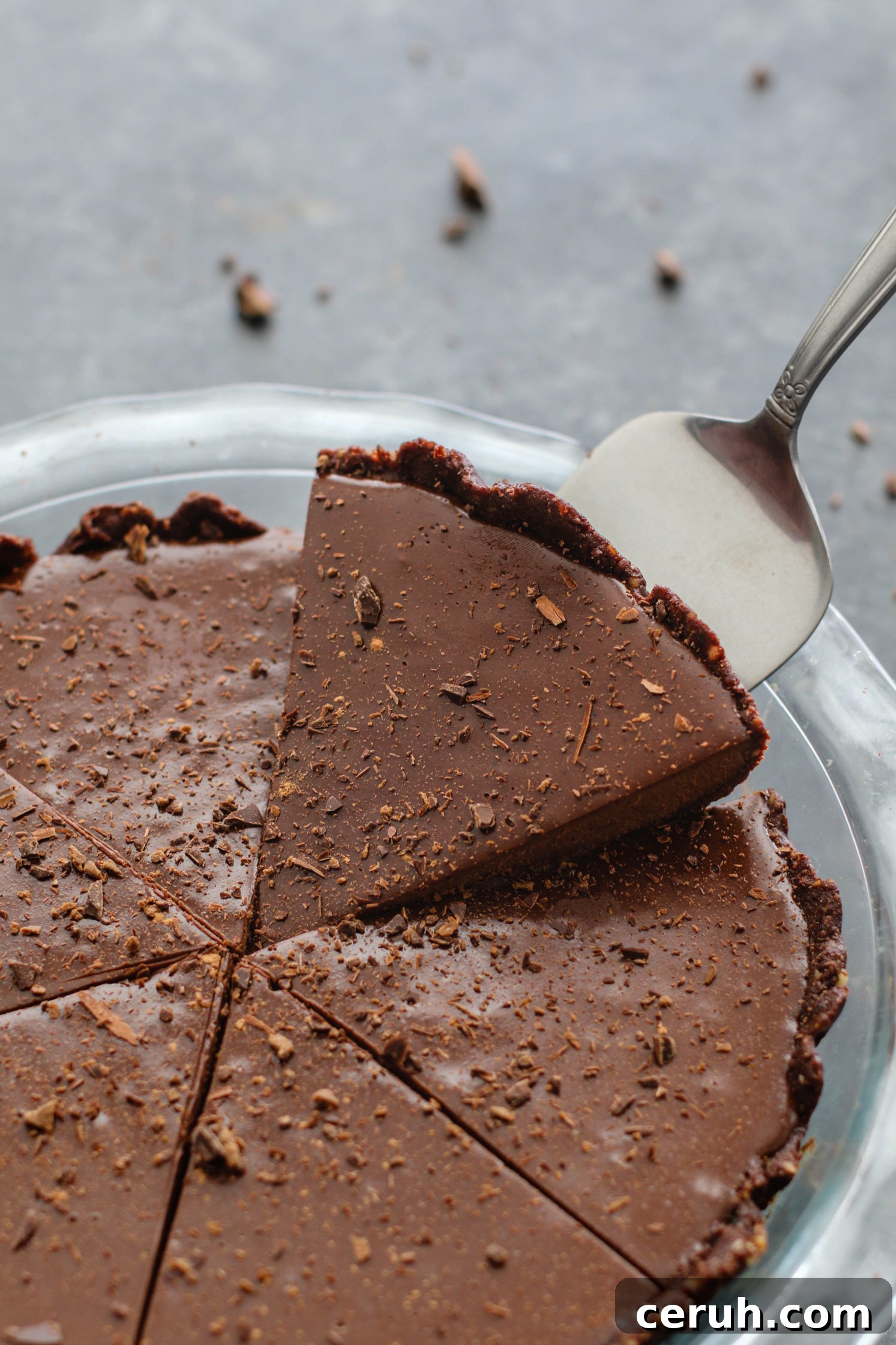 Vegan chocolate pie with slice being removed with pie server by Flora & Vino
