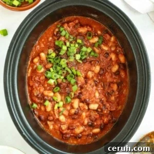 Slow cooker filled with cooked homemade Baked Beans.