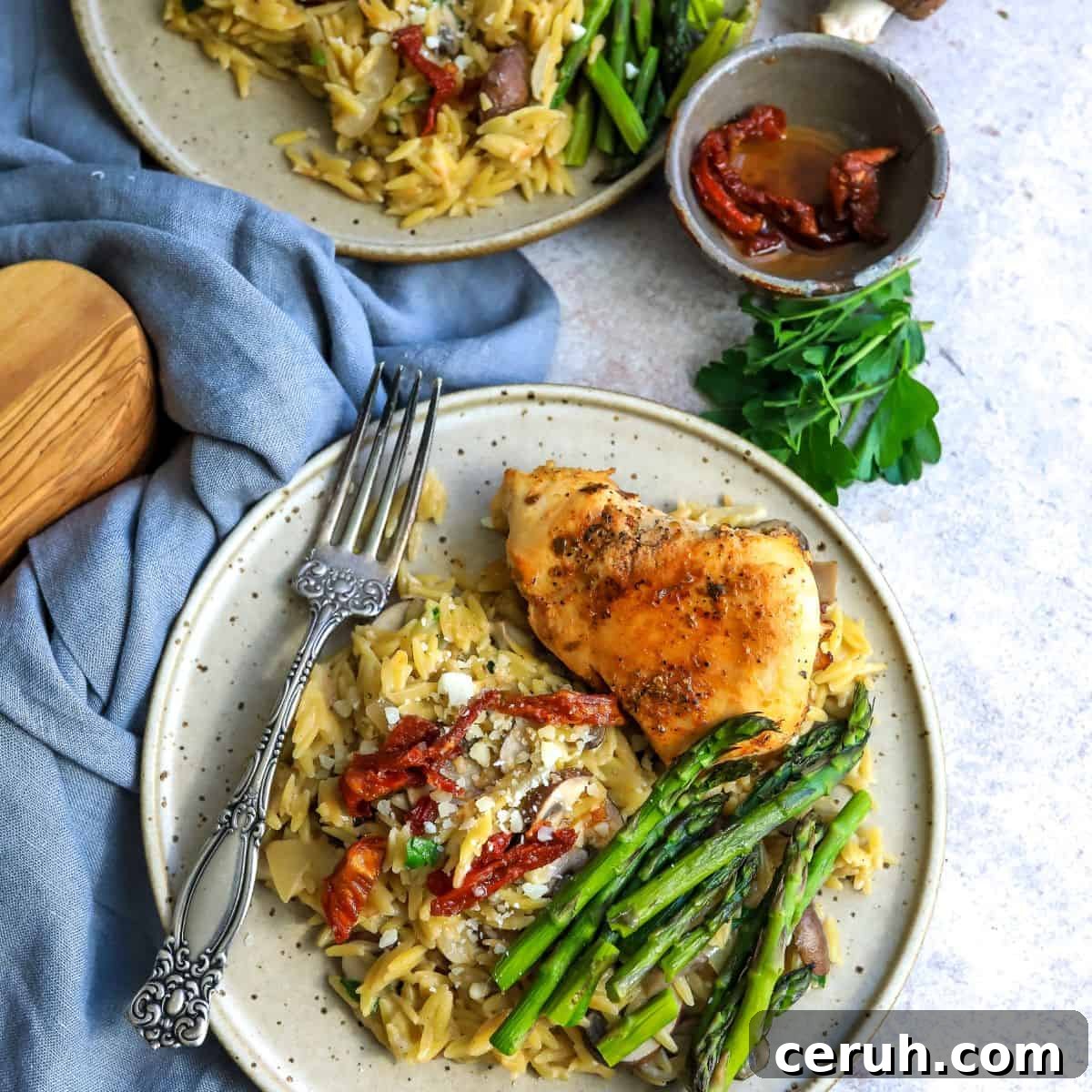 Two plates with creamy orzo  and asparagus.