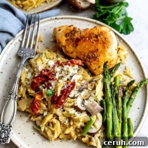 Chicken and orzo on a plate with asparagus.