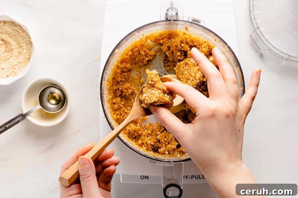 spoonful of apricot bliss ball mixture being felt with fingers