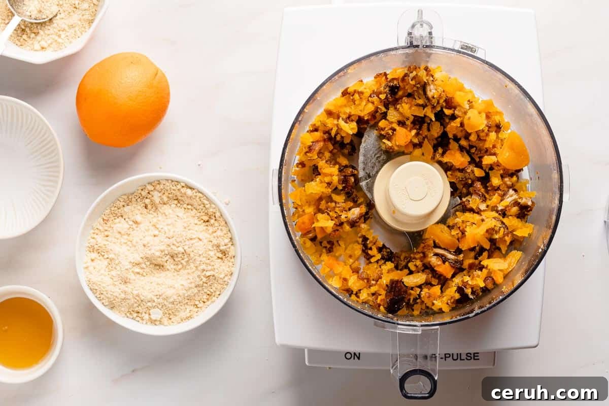 chopped dried fruit in food processor with recipe ingredients on the side