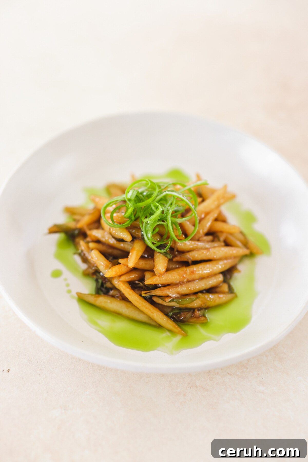 a white bowl of scallion noodles 
