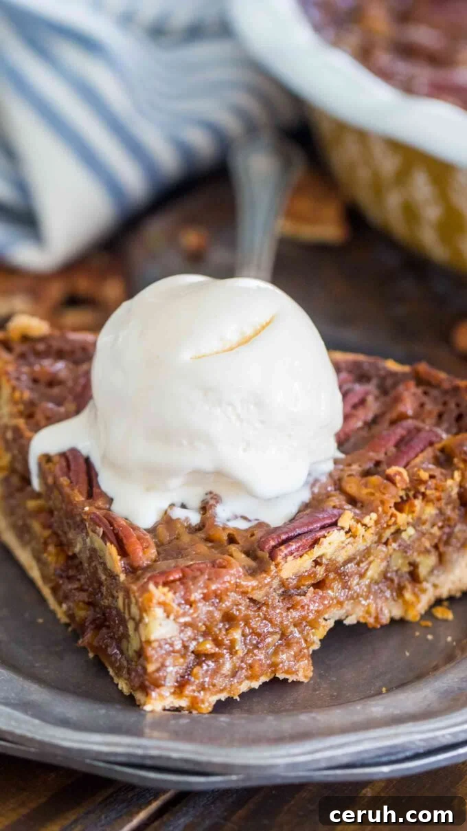 Slice of Homemade Pecan Pie topped with vanilla ice cream.