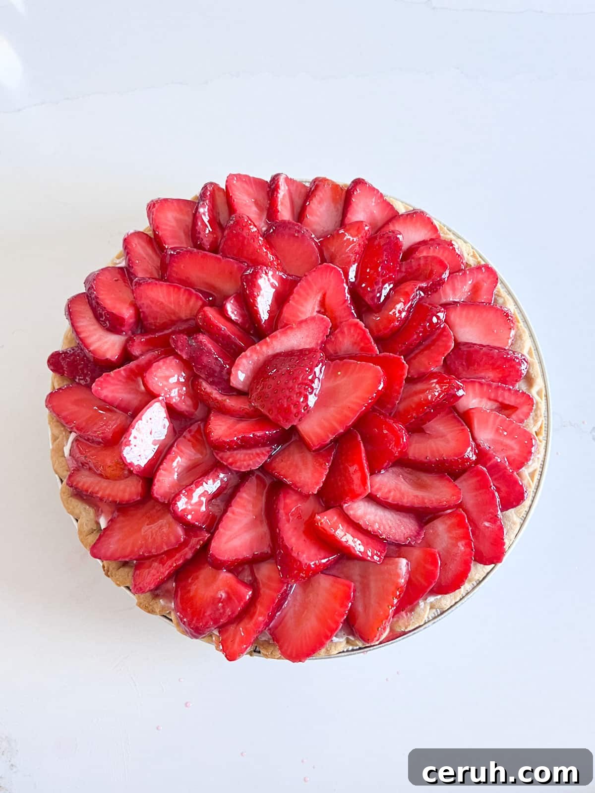 Glazed strawberries shingled onto the top of the pie.