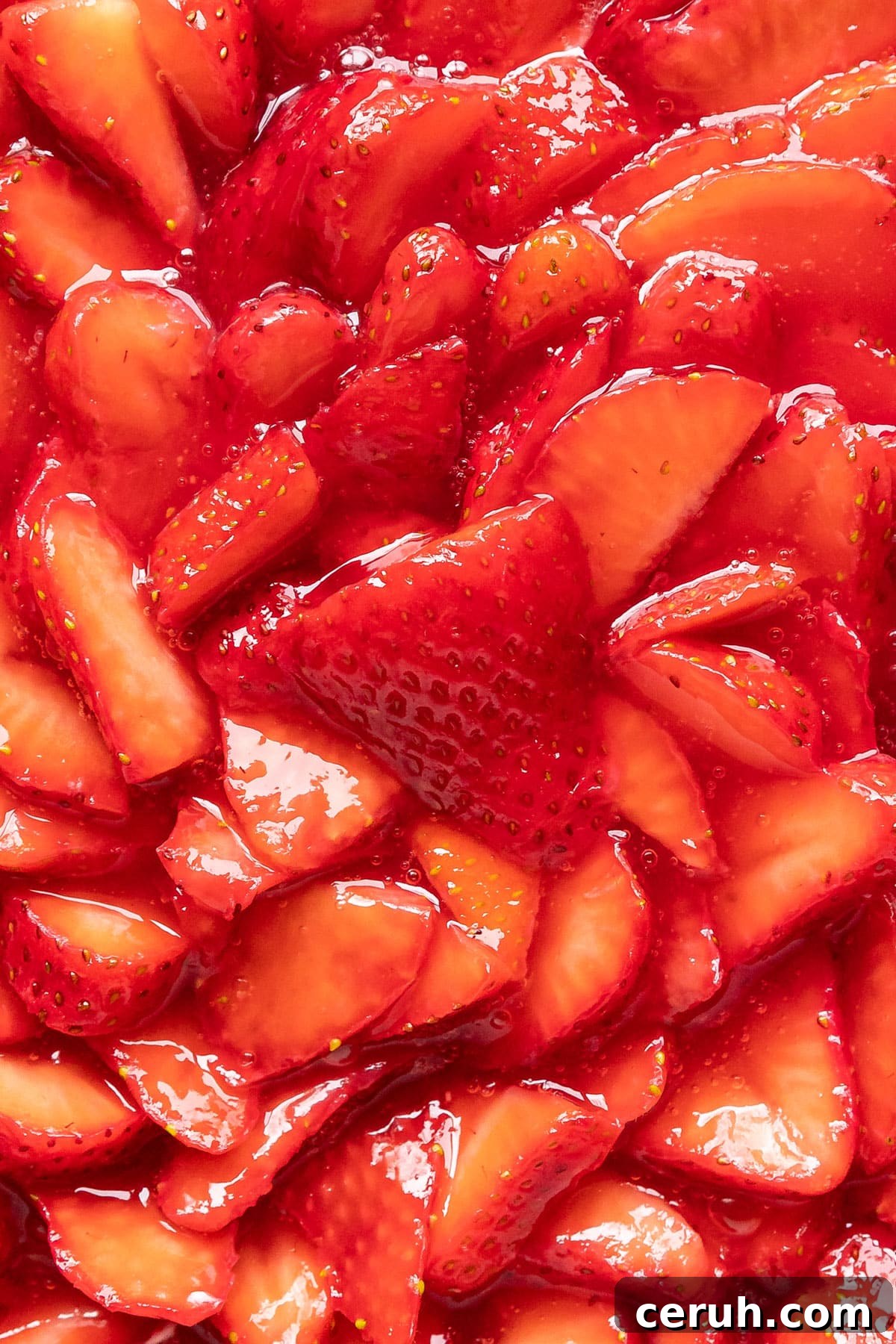 A close up image of the strawberries shingled on top of the pie.