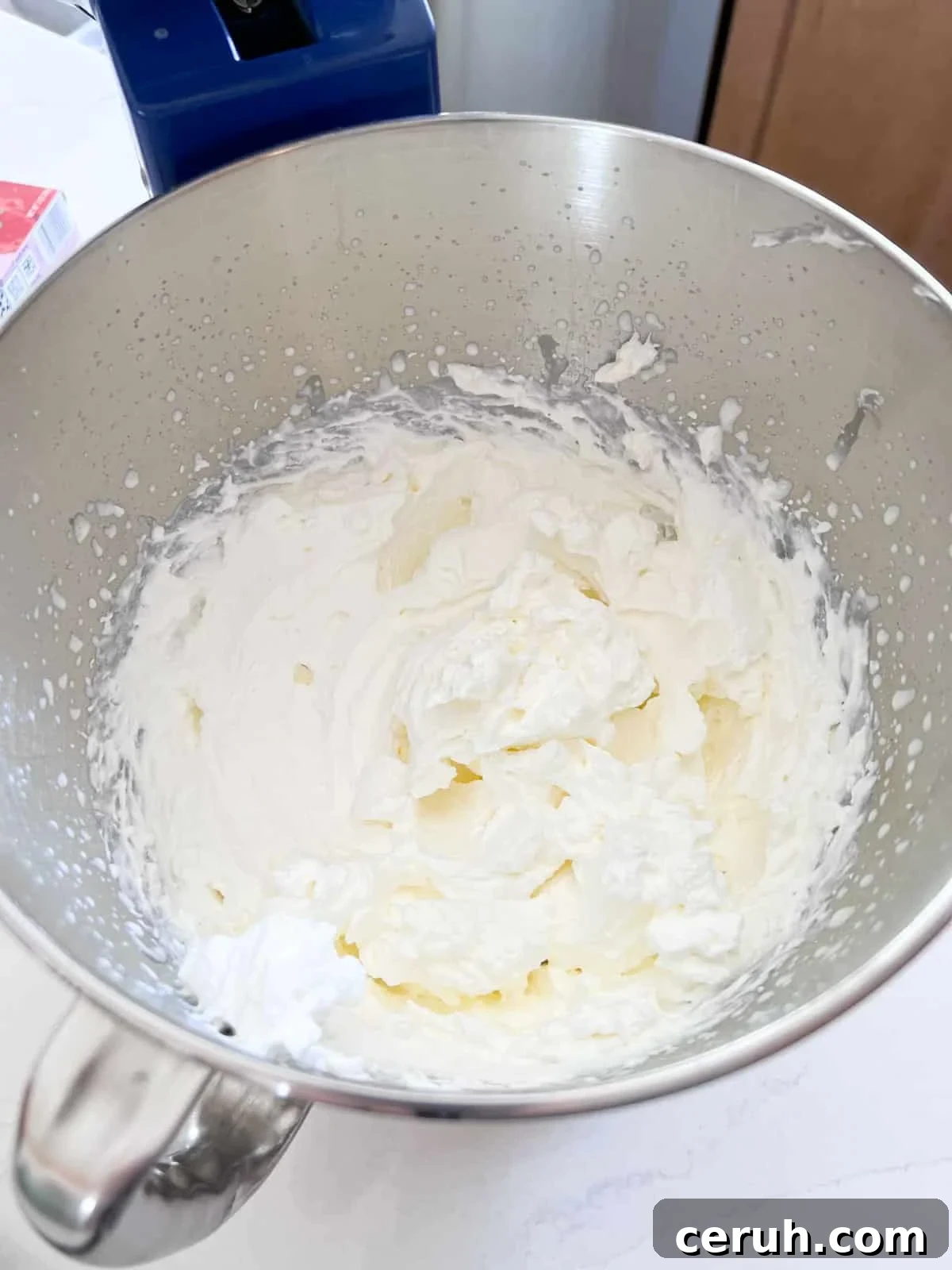 Whipped cream in a stand mixer bowl after being whipped in to stiff peaks.
