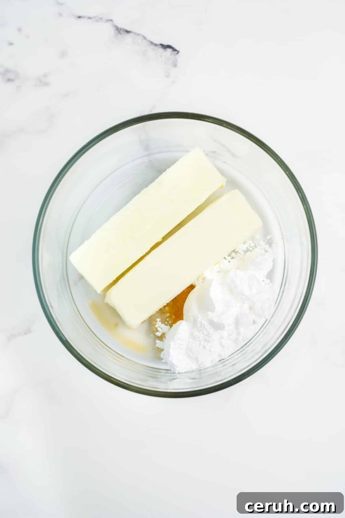 Ingredients for making strawberry butter together in a glass bowl.