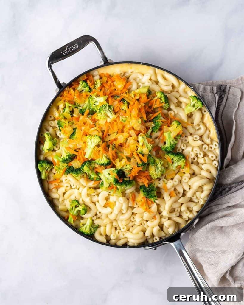 Pasta and vegetables added to a pan.