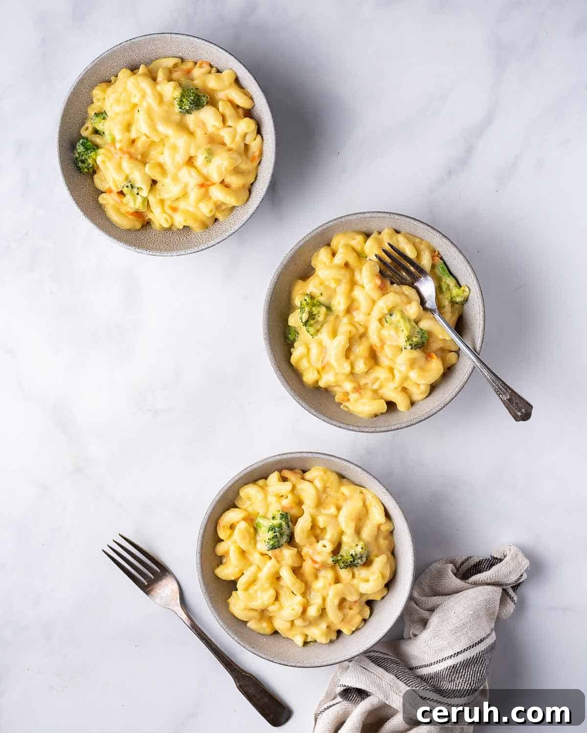 Three bowls of copycat panera broccoli cheddar mac and cheese.