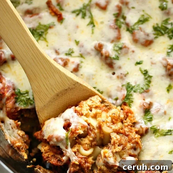 Lasagna in the slow cooker being dished out with wooden spoon