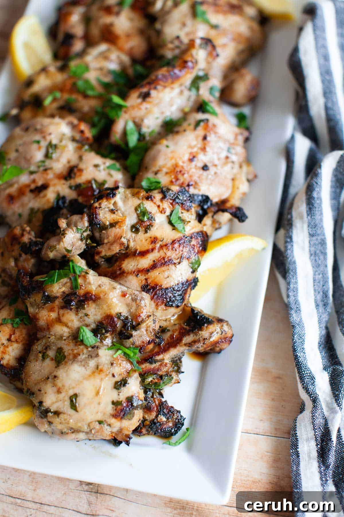 grilled lemon chicken thighs on a white plate