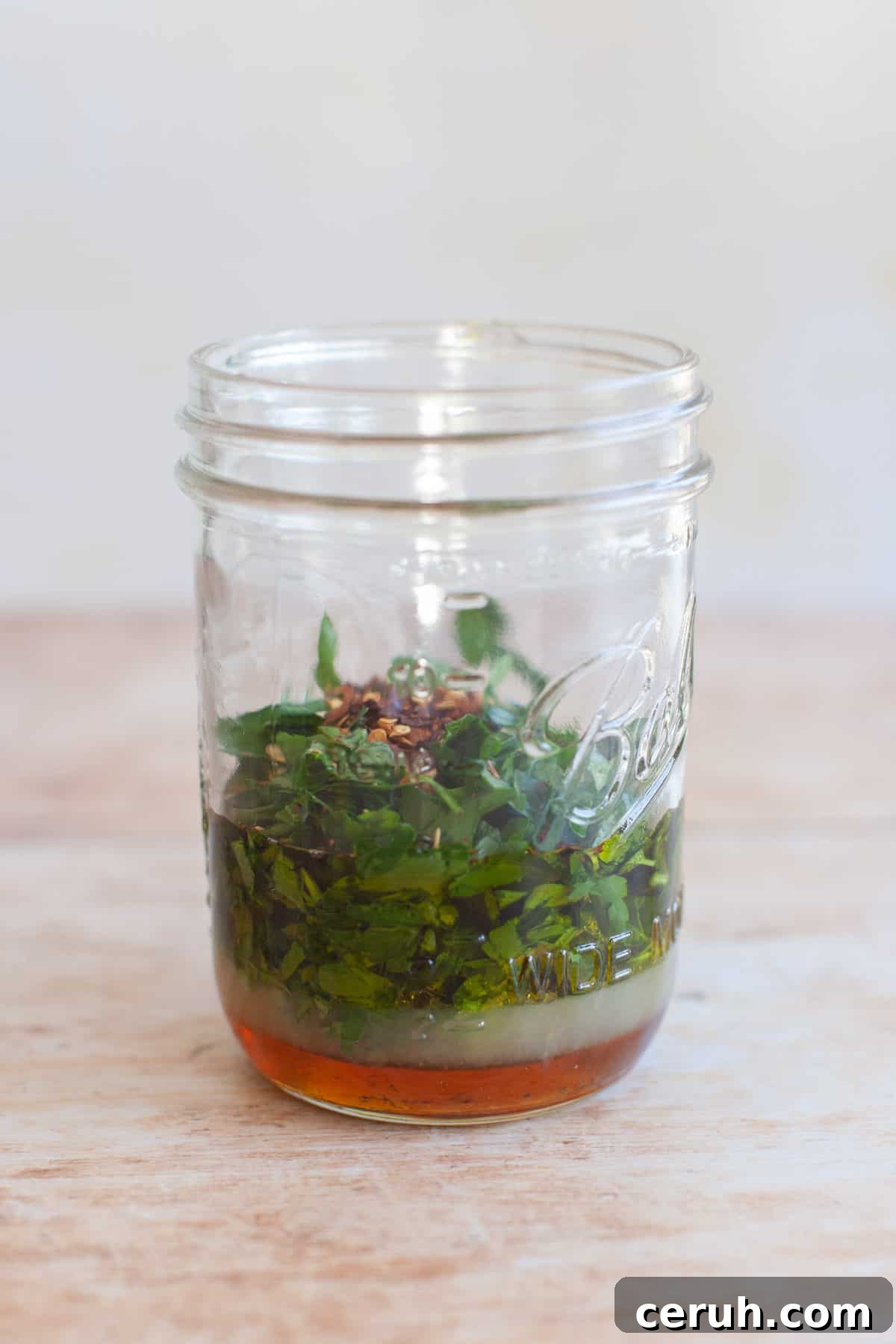 parsley and red pepper flakes in a jar of marinade