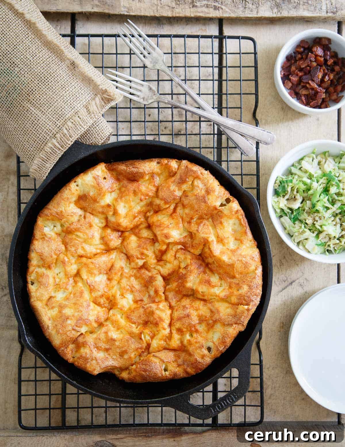 A savory Cheddar Dutch Baby gets topped with bacon and brussels for an easy dinner or brunch.